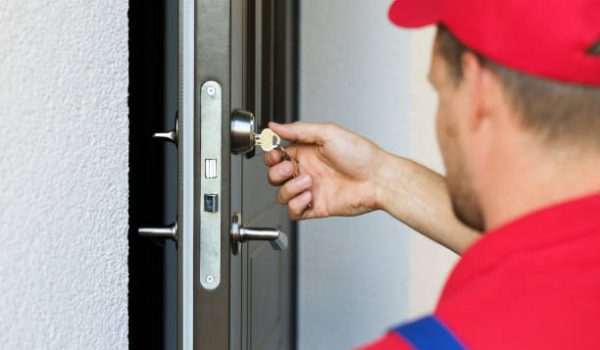 door lock service - locksmith working in red uniform residential locksmith