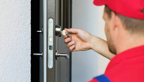 door lock service - locksmith working in red uniform home keys repair